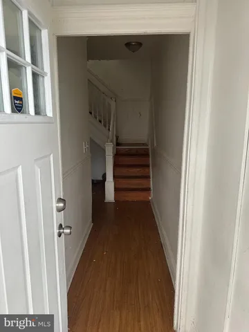 a view of a hallway with wooden floor and entryway