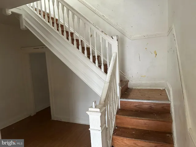 a view of staircase with white walls and railing