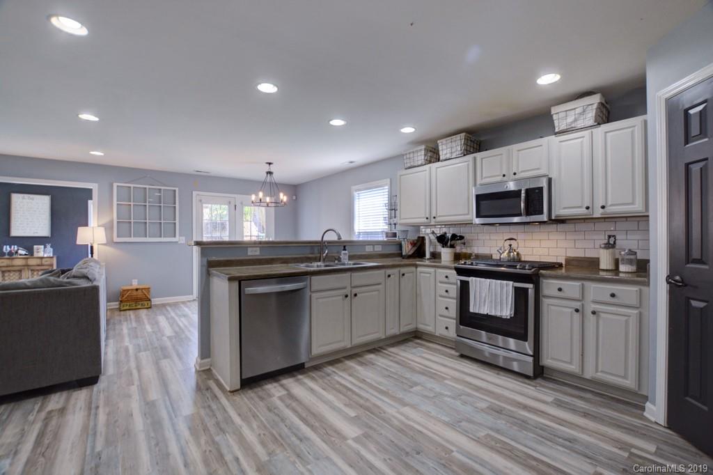 87 Yadkin Road Fletcher, NC 28732 - Photo 18 of 34 a kitchen with granite countertop a stove top oven and cabinets