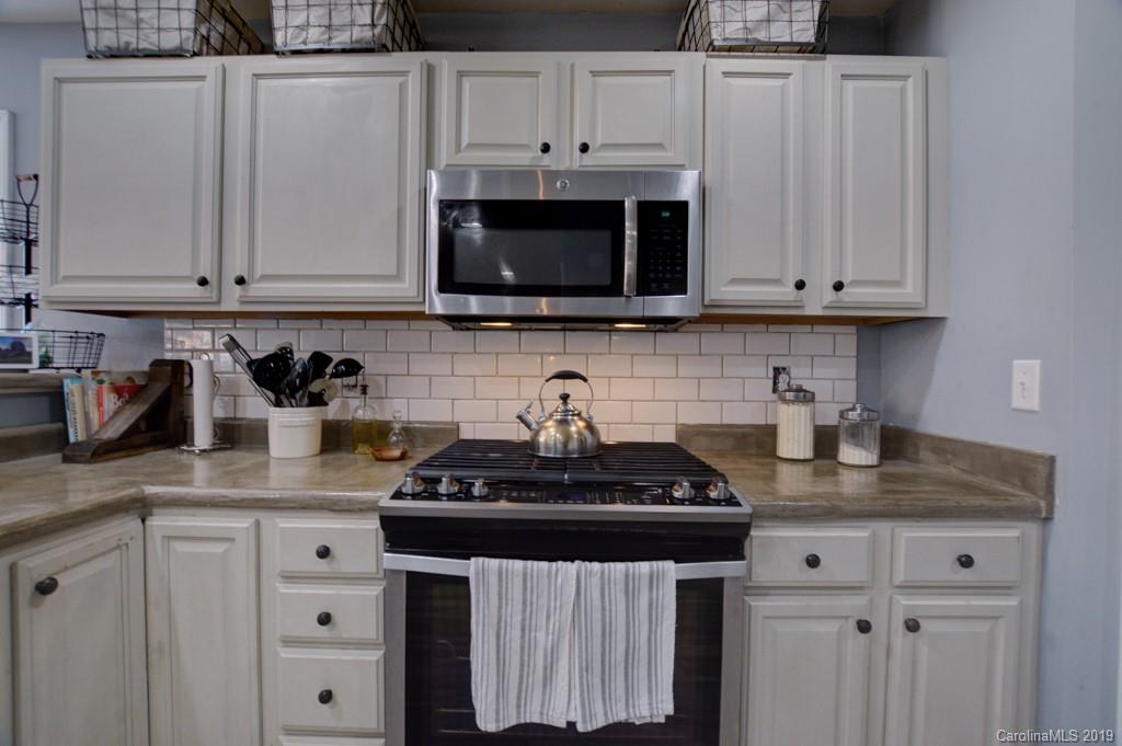 87 Yadkin Road Fletcher, NC 28732 - Photo 19 of 34 a kitchen with stainless steel appliances granite countertop white cabinets a stove a sink and dishwasher