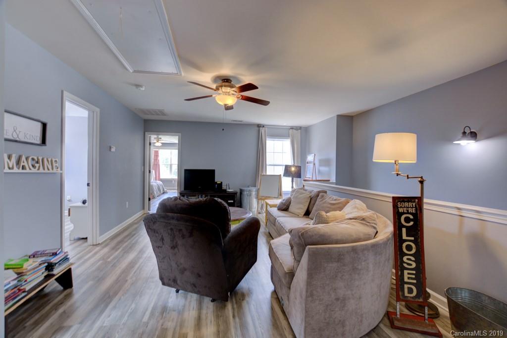 87 Yadkin Road Fletcher, NC 28732 - Photo 28 of 34 a living room with furniture and a wooden floor