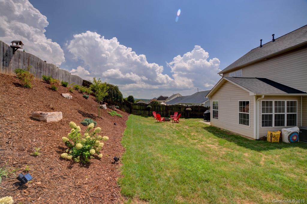 87 Yadkin Road Fletcher, NC 28732 - Photo 4 of 34 a view of a house with a yard and a garden