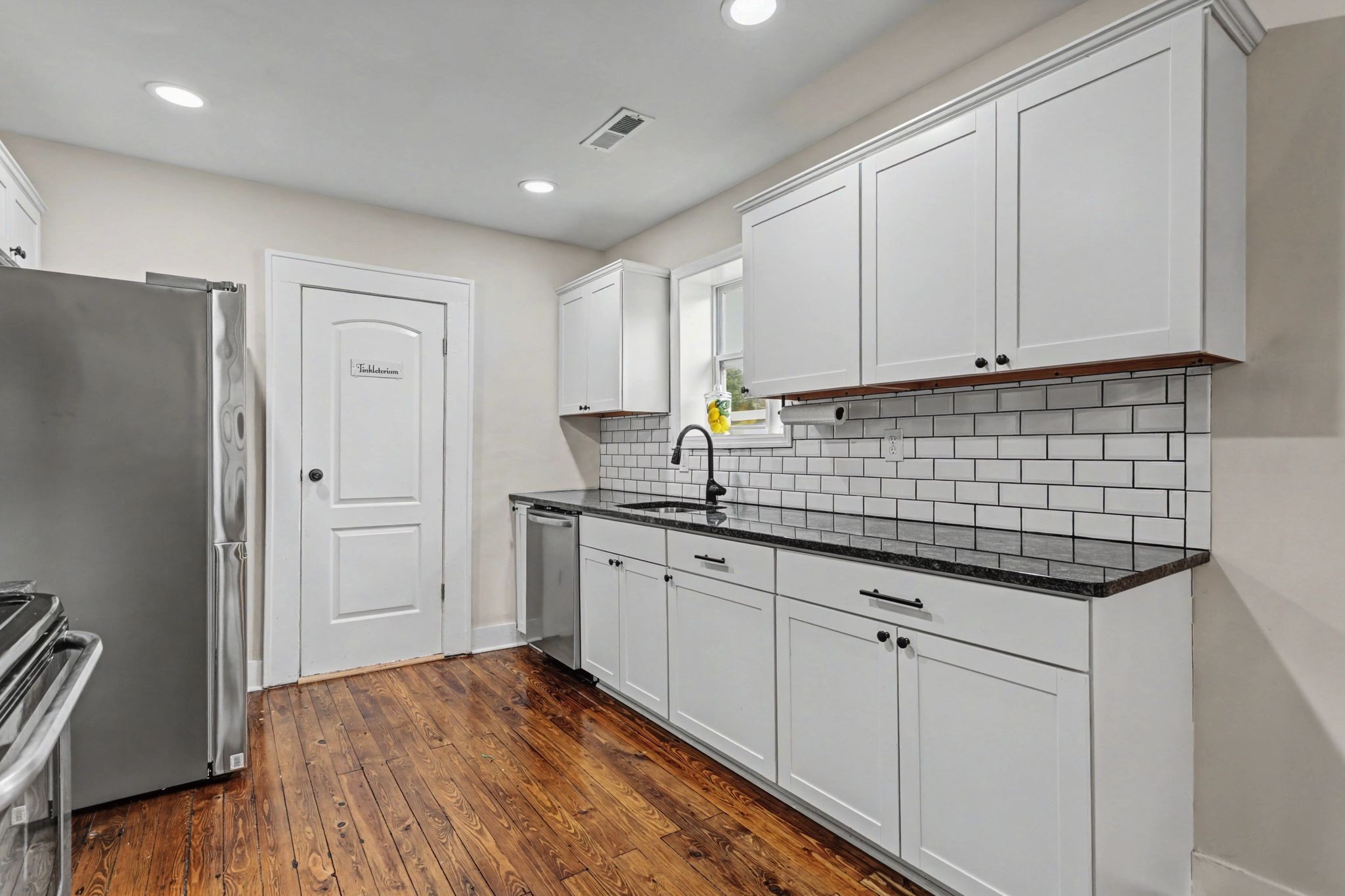 511 Florida Avenue Mount Pleasant, TN 38474 - Photo 11 of 28 a kitchen with granite countertop white cabinets and stainless steel appliances