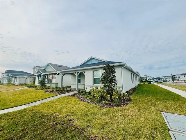 a front view of a house with a yard and trees