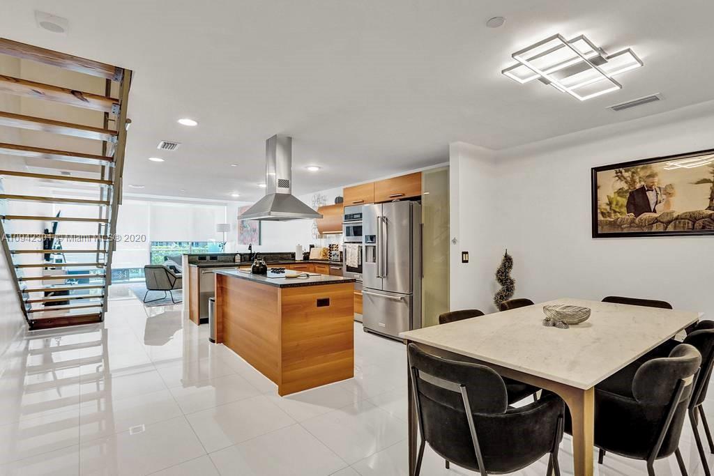 a kitchen with stainless steel appliances a table chairs and stove