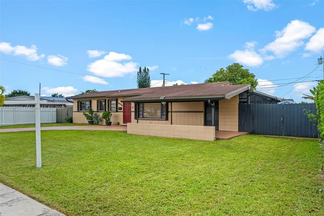 a view of a house with a yard and a patio