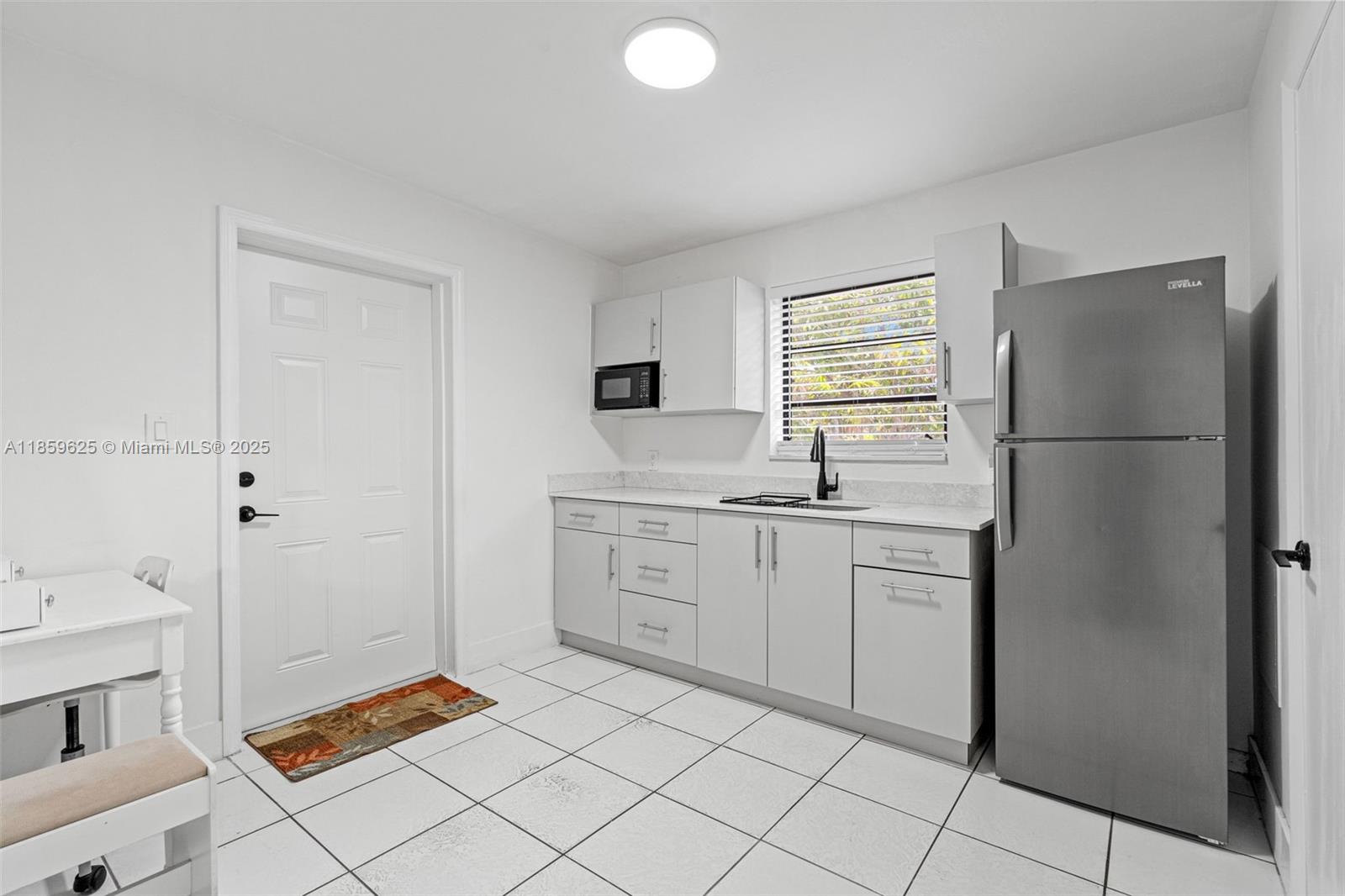 10450 Southwest 43rd Street Miami, FL 33165 - Photo 34 of 43 a kitchen with a refrigerator sink and cabinets