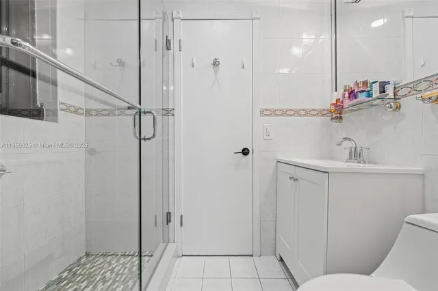 a bathroom with a glass shower door and a sink