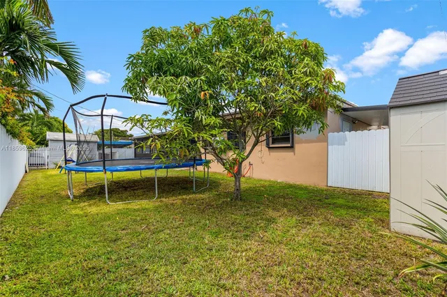 a backyard of a house with table and chairs