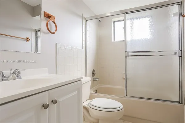 a bathroom with a granite countertop sink toilet a mirror and shower