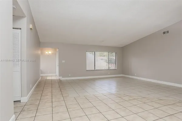 an empty room with white walls and tiles