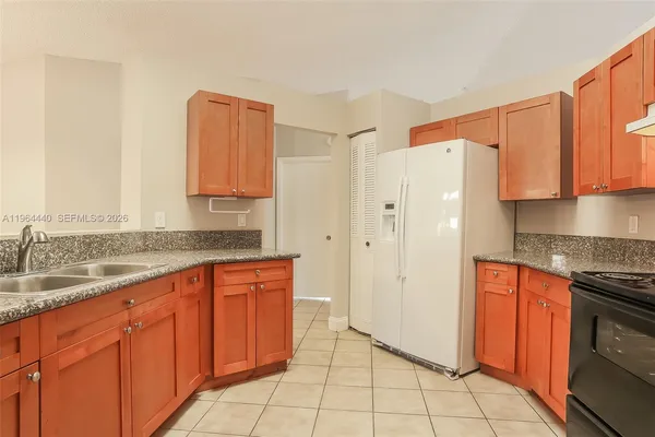 a kitchen with stainless steel appliances granite countertop a refrigerator and a stove