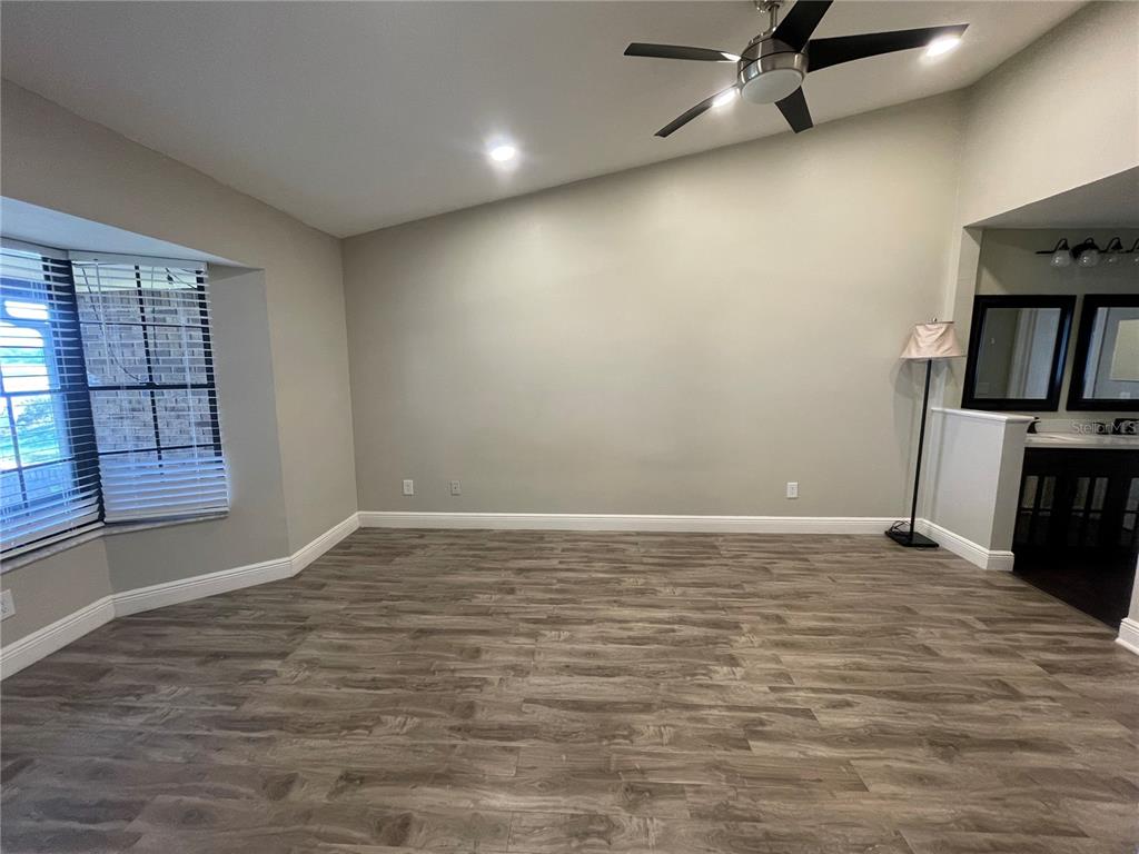 7652 Spring Bay Cove, Unit 3 Orlando, FL 32819 - Photo 13 of 30 a view of an empty room with window and wooden floor