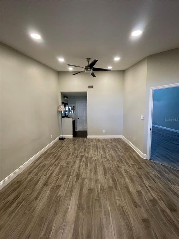 7652 Spring Bay Cove, Unit 3 Orlando, FL 32819 - Photo 14 of 30 an empty room with a wooden floor and a ceiling fan