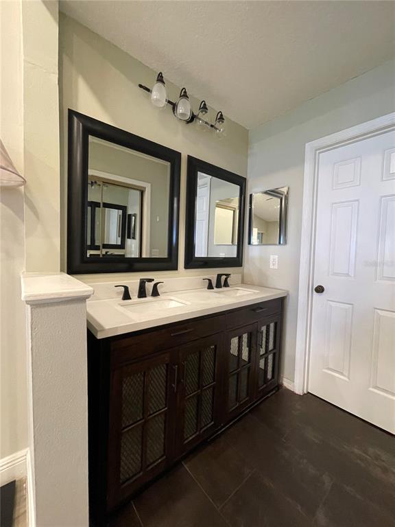 7652 Spring Bay Cove, Unit 3 Orlando, FL 32819 - Photo 15 of 30 a bathroom with a double vanity sink and a mirror