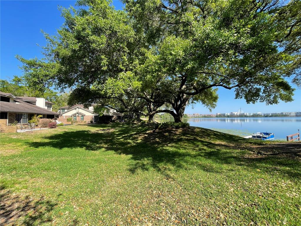 7652 Spring Bay Cove, Unit 3 Orlando, FL 32819 - Photo 28 of 30 a view of a house with a yard and a large tree