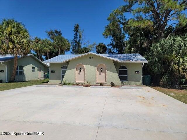 417 Audubon Drive, Unit B Melbourne, FL 32901 - Photo 2 of 12 a front view of a house with a yard and garage