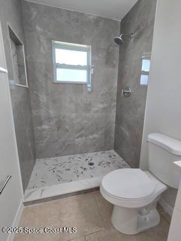 417 Audubon Drive, Unit B Melbourne, FL 32901 - Photo 9 of 12 a white toilet sitting next to a bath tub shower