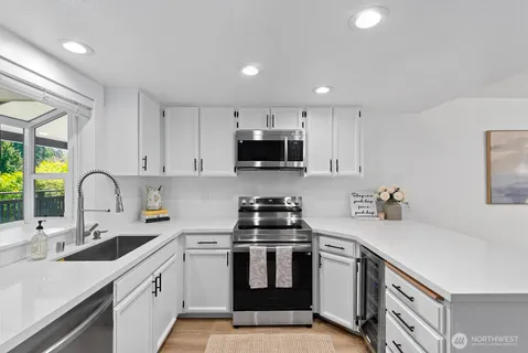 a kitchen with granite countertop a sink stove and cabinets