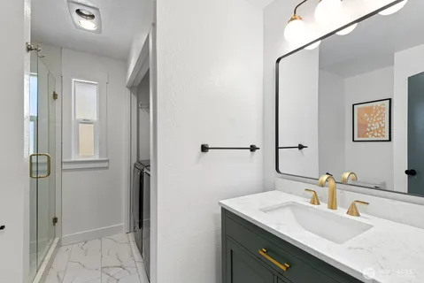 a bathroom with a granite countertop sink and a mirror