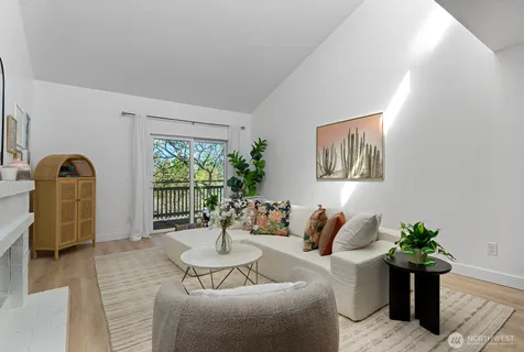 a living room with furniture potted plant and a large window
