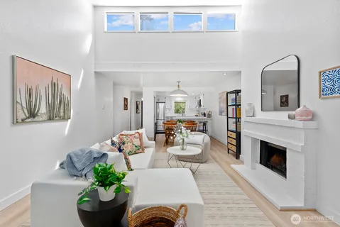 a living room with furniture a fireplace and a potted plant