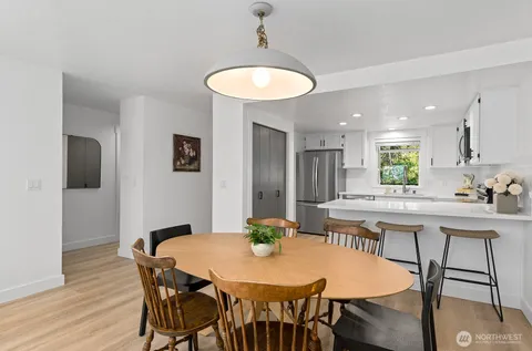 a kitchen with stainless steel appliances a dining table and chairs
