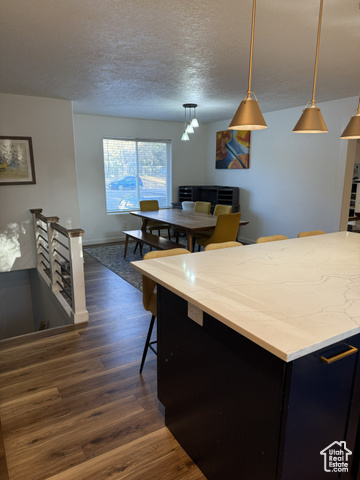 175 North 160 East Hurricane, UT 84737 - Photo 13 of 43 Kitchen with dark cabinets, pendant lighting, a breakfast bar, dark wood-style flooring, and a textured ceiling