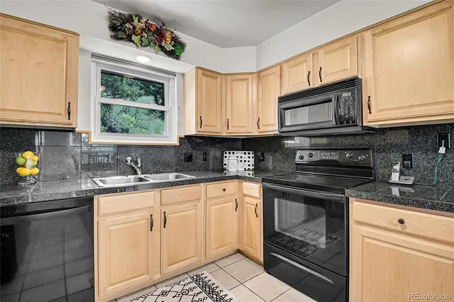 a kitchen with granite countertop a stove sink and cabinets
