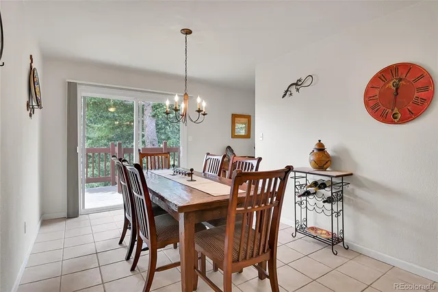 a dining room filled chandelier and wooden floor
