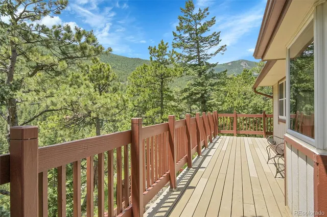 a balcony with wooden floor and yard in the back