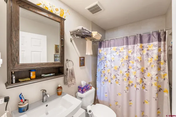 a bathroom with a sink a toilet and shower curtain