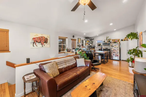 a living room with furniture kitchen view and a chandelier