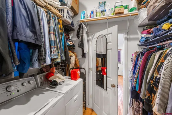 a view of walk in closet with clothes and shoes
