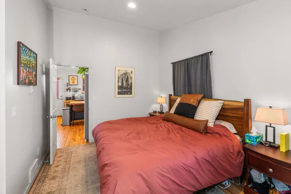 a bed room with a bed and painting on the wall