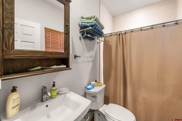 a bathroom with a sink a toilet and shower curtain