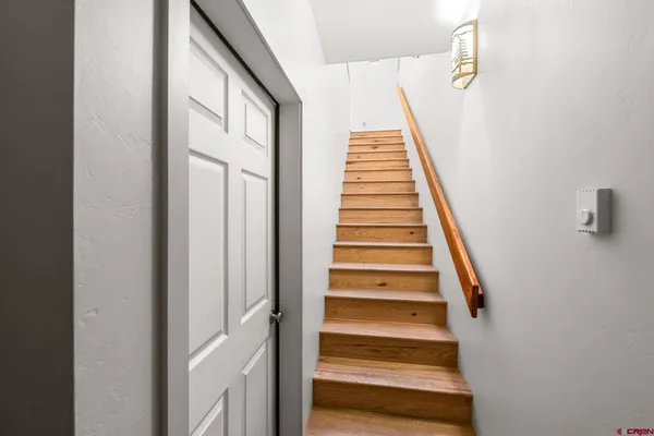 a view of staircase with wooden floor and white walls