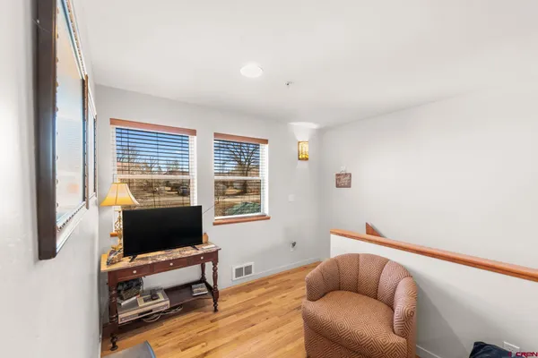a living room with furniture a flat screen tv and a window