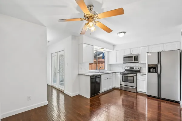 a kitchen with stainless steel appliances a stove a refrigerator and a chandelier