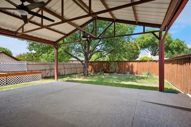 a view of backyard with green space and wooden fence