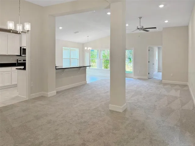 an empty room with kitchen and windows