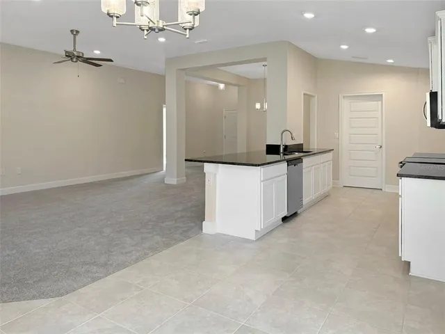 a large kitchen with granite countertop a sink and a refrigerator
