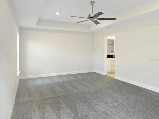 an empty room with a ceiling fan and a window