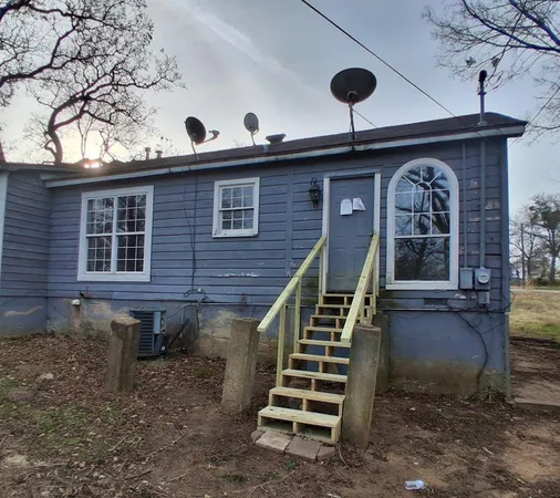 a front view of a house with stairs and plants