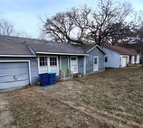 a view of a house with a yard and large tree