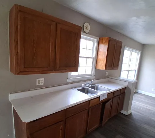 a kitchen with a sink window and cabinets