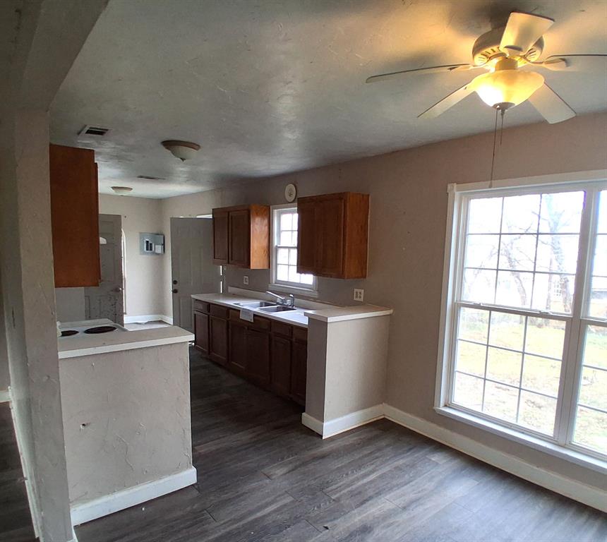 43 West Parnell Street Denison, TX 75020 - Photo 7 of 15 a large kitchen with a window and wooden floor