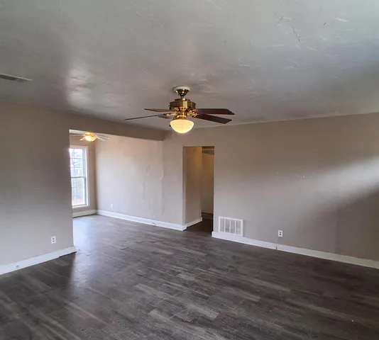 a view of wooden floor and a chandelier fan in a room