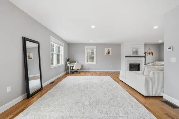 a spacious bedroom with a bed and wooden floor