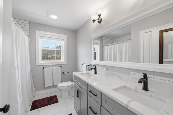 a bathroom with a granite countertop shower sink and mirror